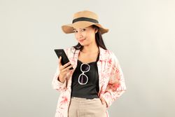 Happy Asian Traveler Woman Joy Relaxing on Summer Vacation Holding Black Smartphone