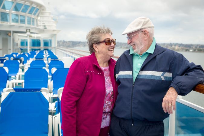 Loving Adult Couple Enjoying The View From Their Passenger Cruise Ship Railing.