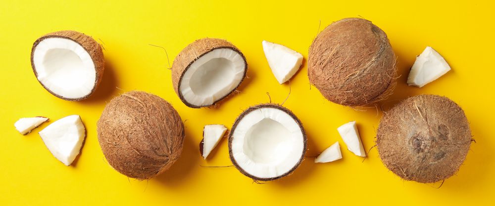 Flat lay with coconut on yellow background, top view