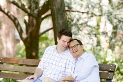 Two men sitting on wooden bench in the park