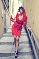 Elegant woman in dress and heels standing on outdoor stairs