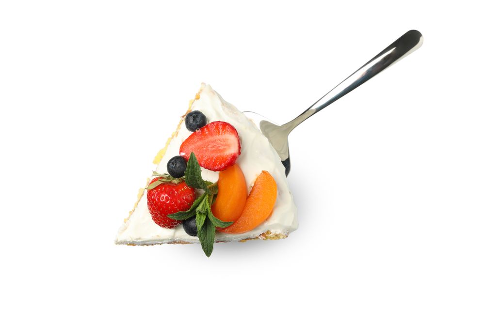 Shovel with berry cream cake isolated on plain background