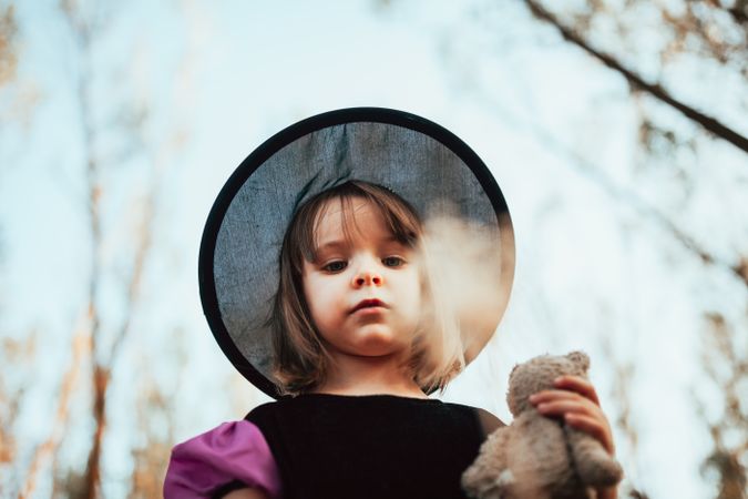 Young girl in witch costume looking down