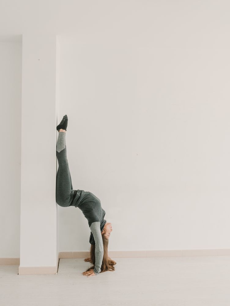 Flexible woman training upside down in studio