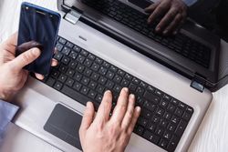 Man using smartphone and laptop