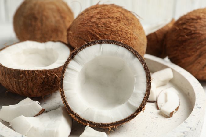Tray with coconut on wooden background, close up. Tropical fruit