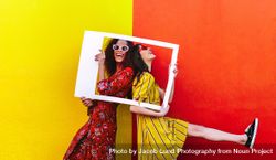 Playful friends posing in front of bright colored wall 5pNBNb