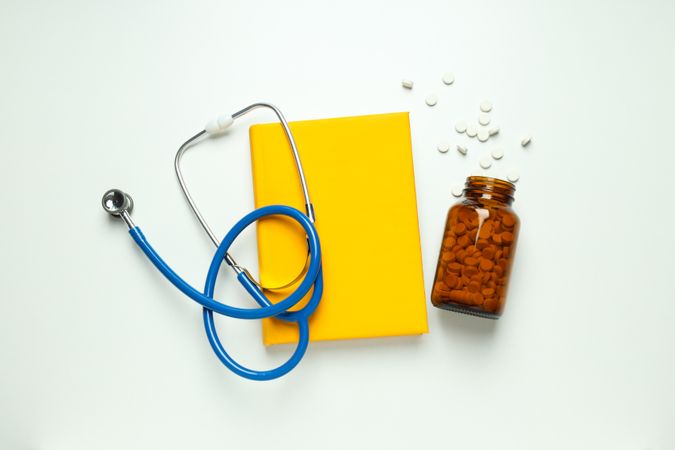 Medical literature - book and doctors accessories on light background