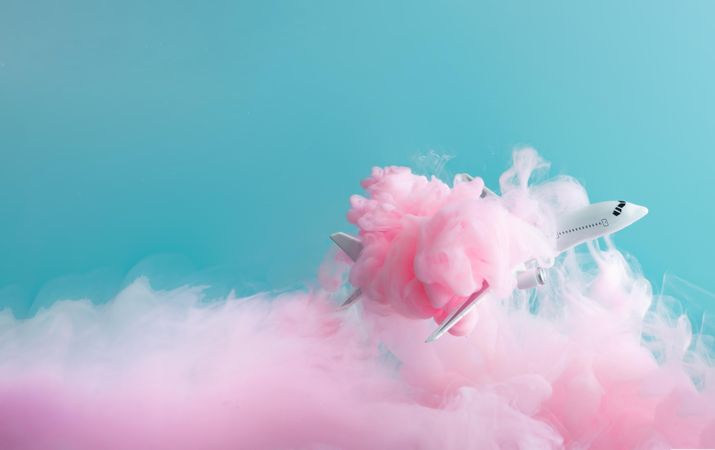Cloud-like pink color paint with airplane on blue background