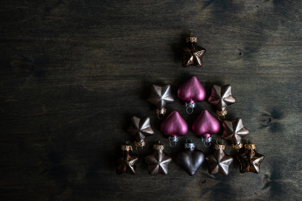 Shape of tree on wooden table made out of Christmas baubles