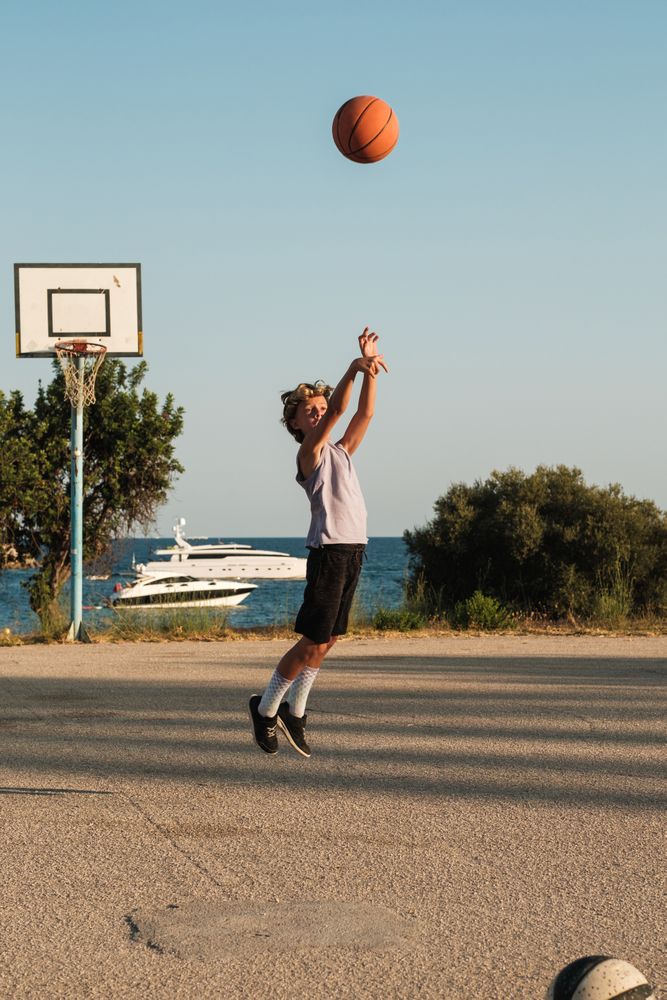 Boy playing basketball on sports ground
