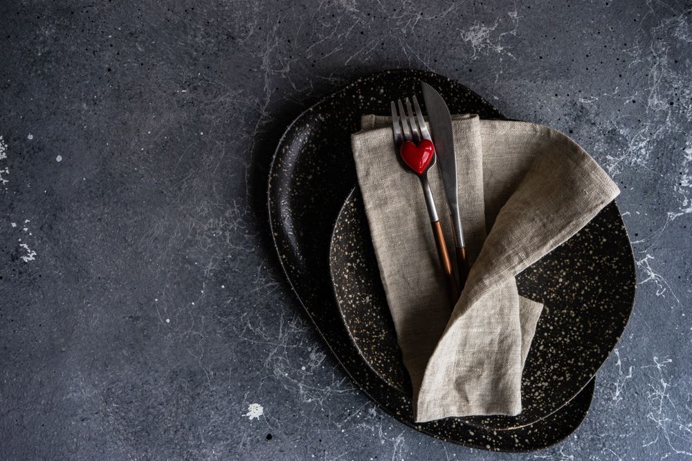 Top view of table setting with heart ornament and napkin