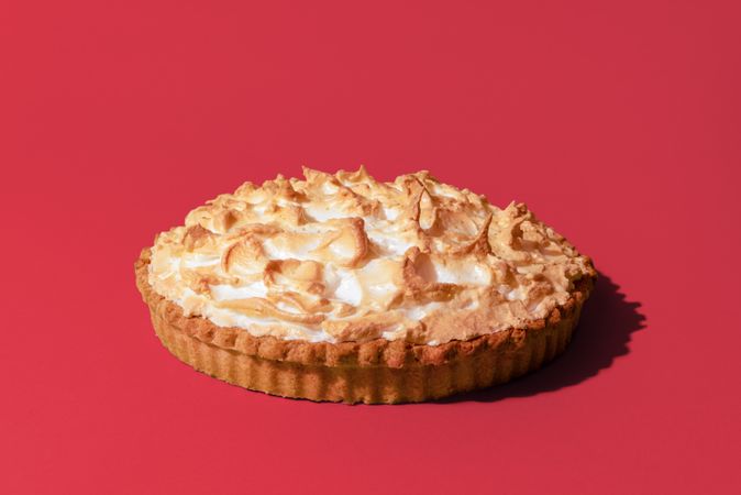 Delicious lemon meringue pie isolated on a pink background
