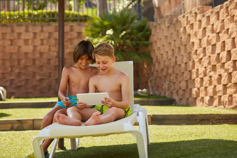 Boys using tablet in garden