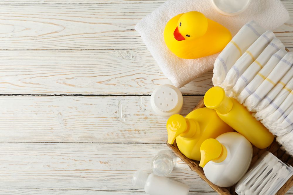 Baby hygiene accessories on wooden background, top view