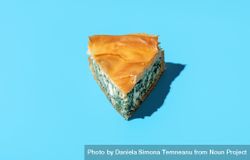 Spinach pie slice minimalist on a blue background 4Mdm15