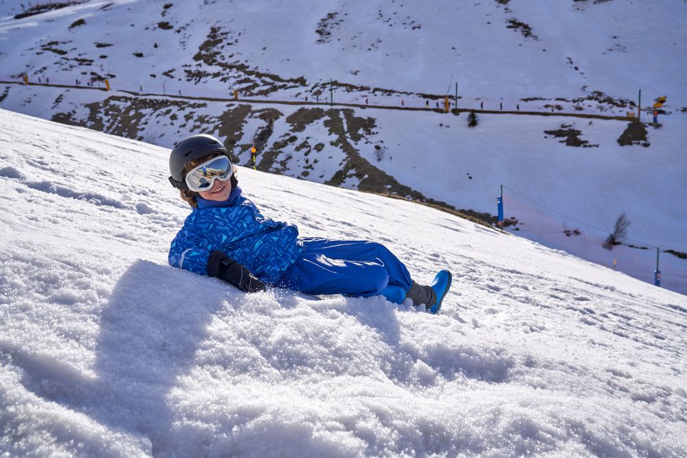 Child lying on snowy slope