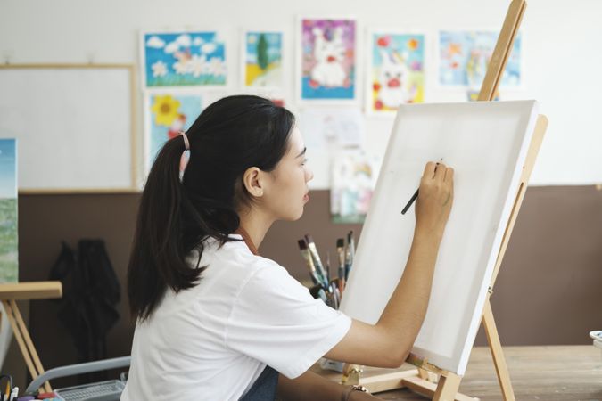 Crafting Inspiration: Female Artist Sketching and Painting in Workshop