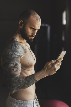 Athlete with smartphone in gym