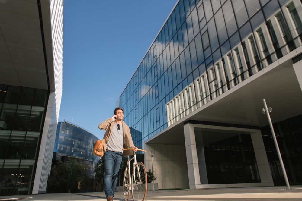 Man phoning while standing against modern building in downtown