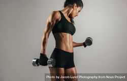 Strong woman lifting weights over gray background 5Q23pV