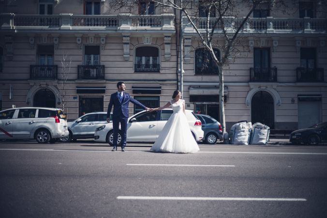 Newlyweds holding hands on road