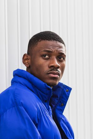Black stylish man in warm jacket on street