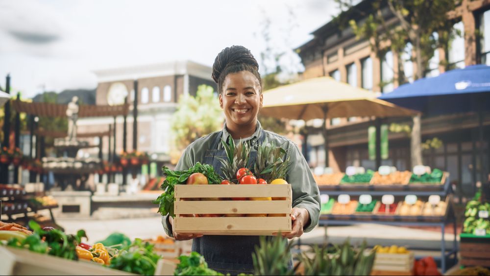 Portrait of a Black Female Working at a Farmers Market Stall with Fresh Organic Agricultural Products.