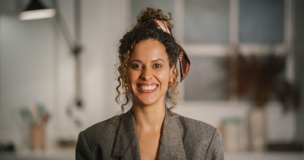 Portrait of Multiethnic Female with Curly Hair Looking at Camera and Smiling.