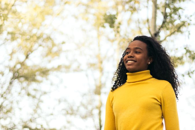 Black woman walking and smiling in a park
