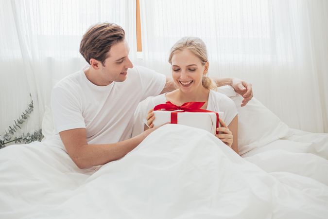 Happy couple is celebrating their anniversary together in the bedroom at home