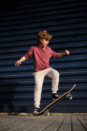 Little skater doing trick on street