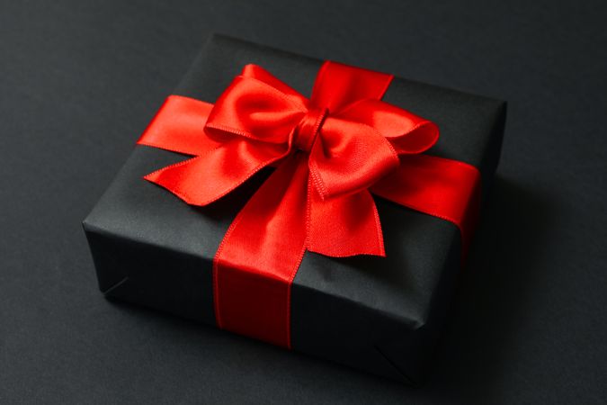 Gift box with red bow on dark background