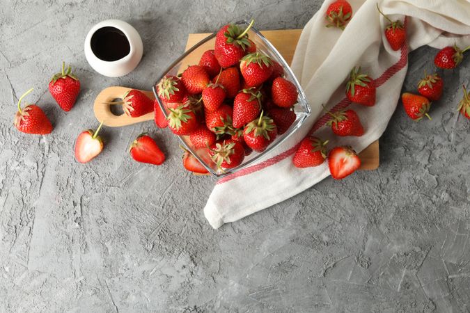 Composition with bowl of tasty strawberry on gray table. Summer berry