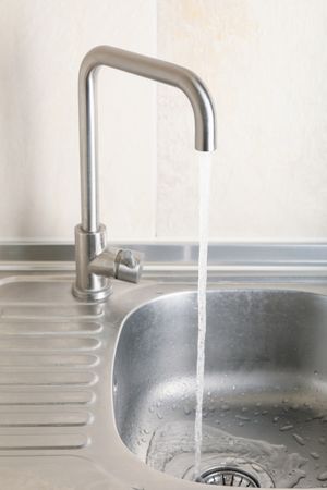 Water flowing from the tap in the kitchen sink