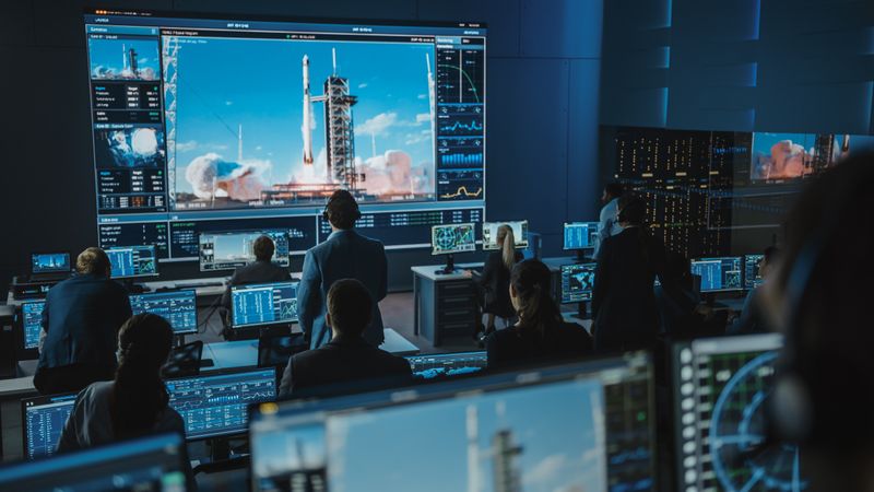 Mission Control Team Observes Rocket Launch on Giant Screen.