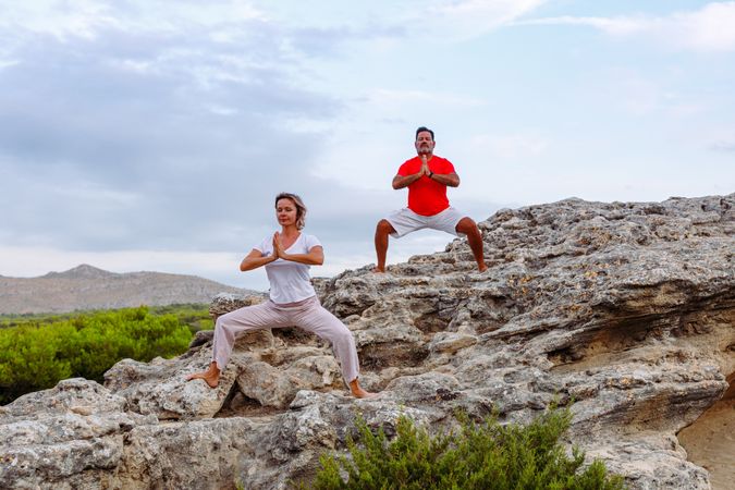 Couple meditating on rock