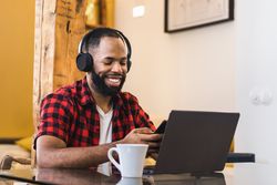 Black man teleworking with laptop from home