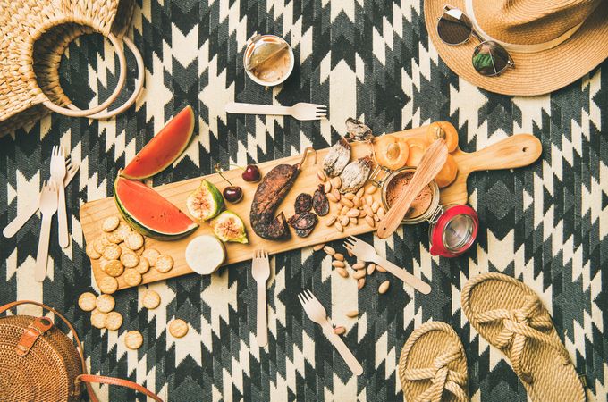 Summer picnic on pueblo pattern blanket, with board of pate, meats, and fruit