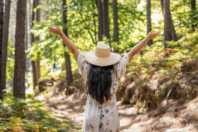 Woman enjoying a day in nature, walking through the forest