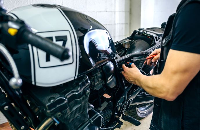 Motorcycle mechanic changing a fuse