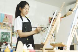 Crafting Inspiration: Female Artist Sketching and Painting in Workshop