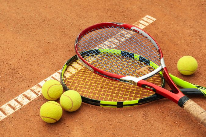 Tennis racquets with tennis balls on clay court