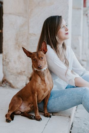 Woman with purebred dog on stone porch