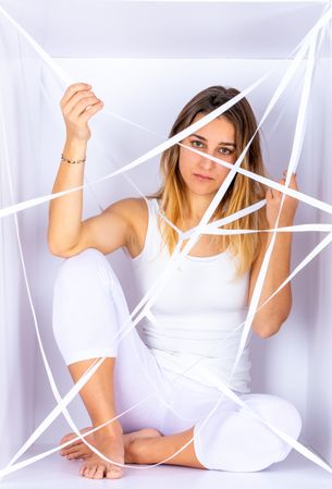 Woman in white box with straps