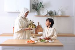 Mom and Daughter Preparing Ketupat Lebaran for Eid Al Fitr Celebration at Home.