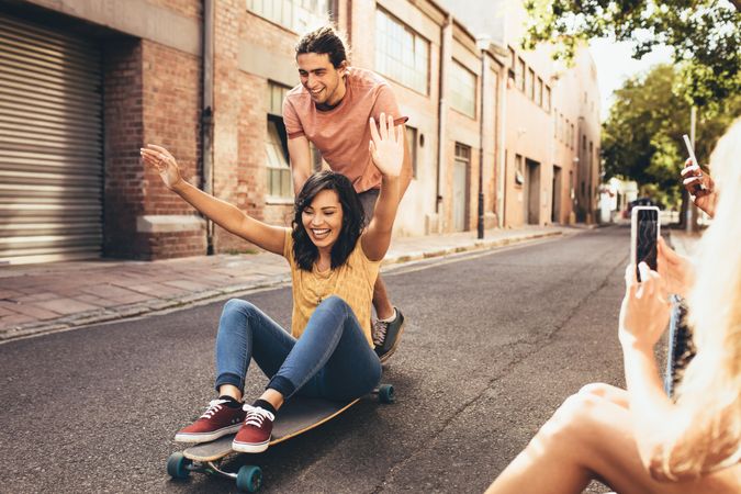 Two people having fun on skateboard with friends taking their pictures