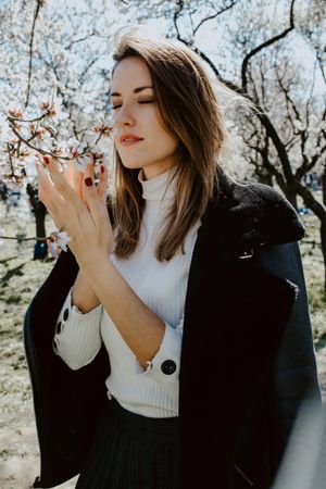 Young happy woman between trees in garden