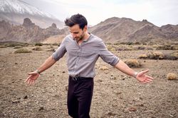 Happy young man enjoying carefree time in mountains during trip