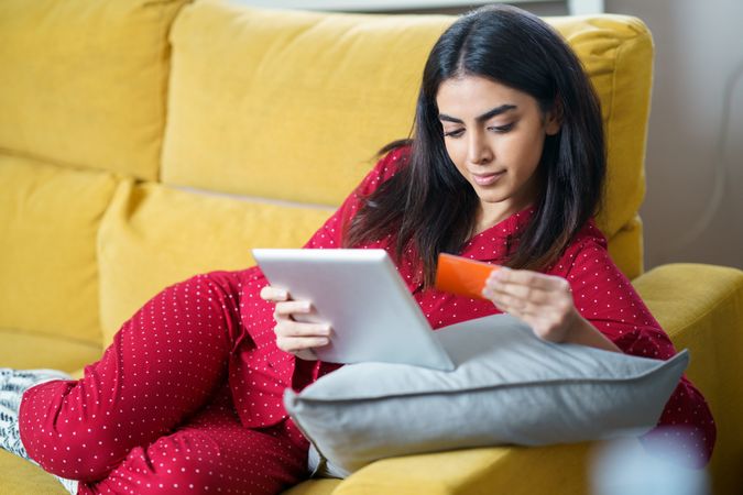 Woman shopping at home on tablet with credit card